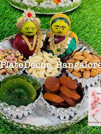 A close-up of one of my wedding platters, featuring traditional Marapachi Bommai figurines made from apples. The platter is filled with high-quality dry fruits like pistachios, cashews, and almonds, all arranged in an ornate silver tray.