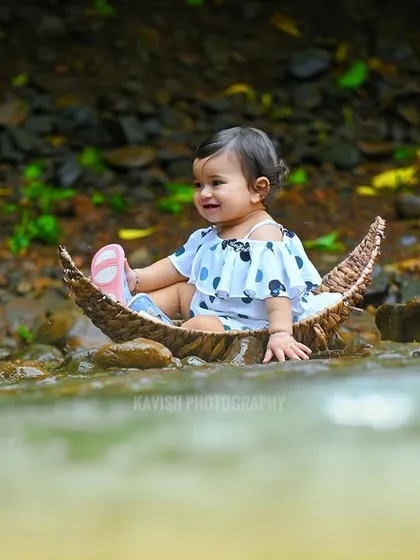 A serene portrait of the baby girl in the boat, looking thoughtfully at the water.