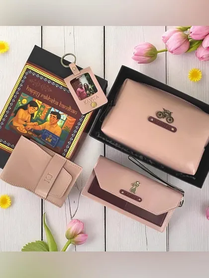 A coordinated Rakhi gift set for a sister in a lovely blush pink vegan leather. The hamper includes a clutch, wallet, and a personalized keychain with a photo, all in a festive box.