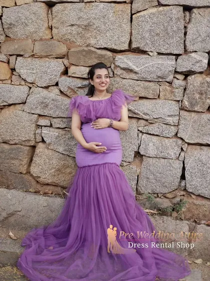A beautiful portrait showcasing the flattering fit of the lavender mermaid gown. The ruffled neckline and fitted bodice are designed to make you feel elegant and confident during your maternity shoot.
