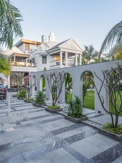 The dramatic arched wall not only defines the driveway but also frames beautiful vignettes of the garden, creating an experience of discovery with every step.