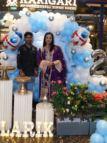 I was so happy to be part of this special day for actress Sanjjanaa Galrani and her son Alarik. This photo captures our team member alongside the happy client in front of the space-themed balloon backdrop we designed for the event.