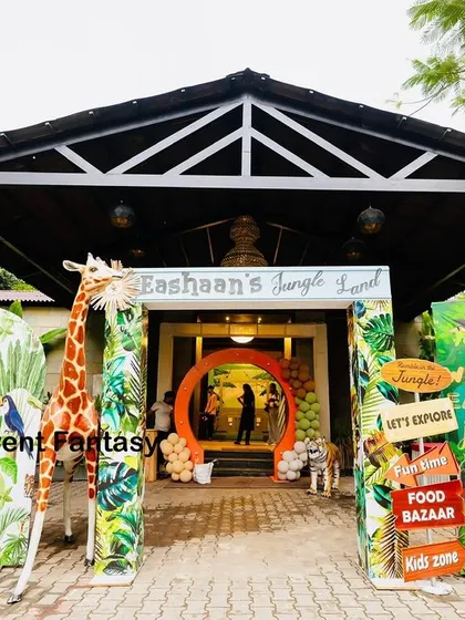 A grand welcome to "Eshaan's Jungle Land." The entrance is framed by vibrant, jungle-themed panels, a life-sized giraffe prop, and a custom welcome sign, setting an adventurous tone from the moment guests arrive.