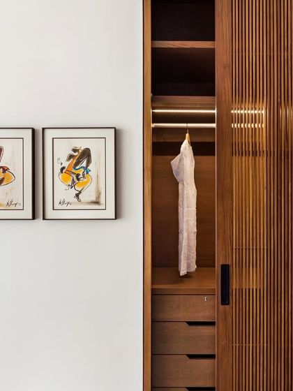 A detail of a ribbed walnut wardrobe in the Limestone Residence. The sliding door reveals integrated lighting, a feature we often use to combine practicality with a touch of luxury.