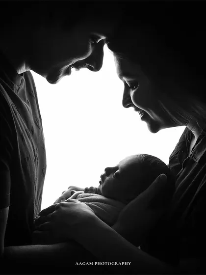 A similar silhouette style, showing the intimate bond of a new family. These sessions are best within the first 7-15 days to capture that tiny, curled-up newborn look.