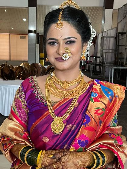 This bride looks like royalty in her vibrant Paithani saree. I used a classic makeup style with a prominent nath and bindi to complete her traditional Maharashtrian wedding look.