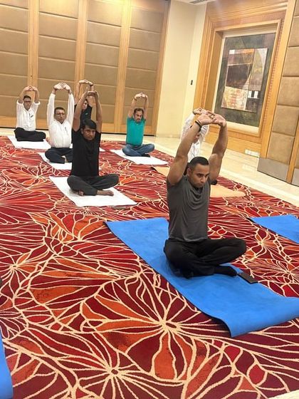 Another view of the seated stretching session, showing the group moving in unison. Group practice helps build a sense of team unity and shared experience.