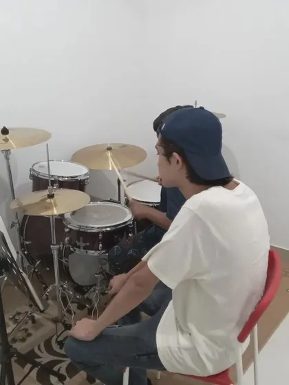 Another shot of a drum lesson, showing the instructor guiding the student.
