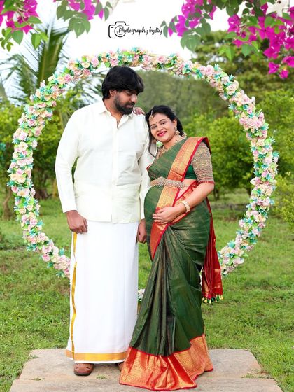 A classic couple's portrait in traditional South Indian attire, framed by a circular floral prop in our outdoor location.