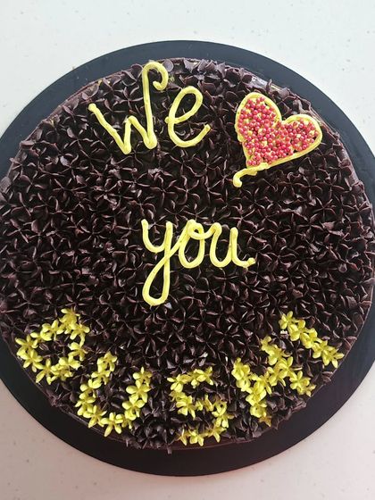 A simple and heartfelt chocolate cake with a message of love. The surface is covered in tiny, piped chocolate stars, showing a different texture I can create with frosting.