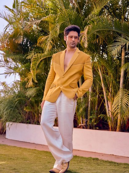 Sunshine, stitched to perfection. This bright yellow blazer from the Sukoon collection, paired with breezy white trousers, brings all the energy needed for a day function.