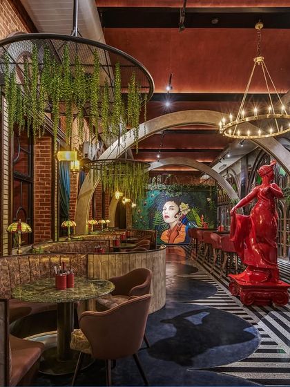 Another view of Suzy Q's interior, highlighting the curved booth seating and the bold red statue. This project taught us how to create impactful designs that balance functionality and bold aesthetics.