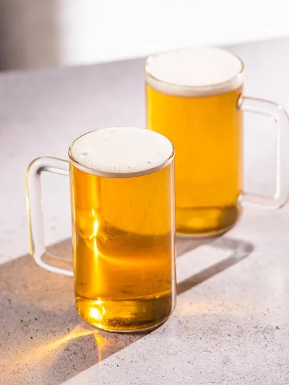 A minimalist shot of Borosil's beer mugs. The clean, hard light creates beautiful reflections and highlights the clarity and modern design of the glass.