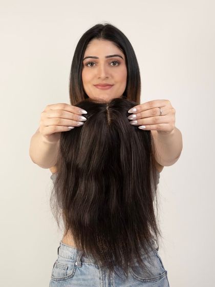 A model holding a hair topper, showing the hair quality and natural look.