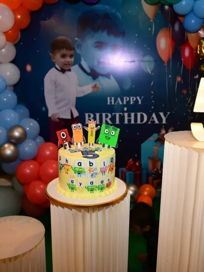 A fun and educational Numberblocks-themed birthday party. The setup includes a custom backdrop with the birthday boy's photo and a large light-up number '5'.