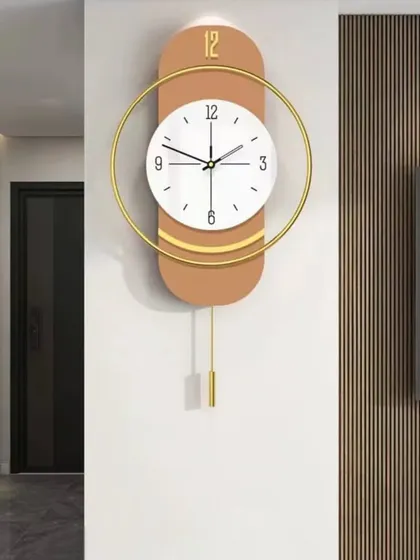 This pendulum wall clock offers a warm and inviting aesthetic with its terracotta-colored backing and clean white face. The golden circular accent adds a touch of modern elegance, making it a stylish addition to any room.