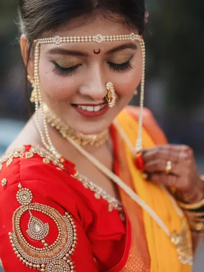 A close-up portrait focusing on the bride's expressive eyes and the traditional mundavalya on her forehead.