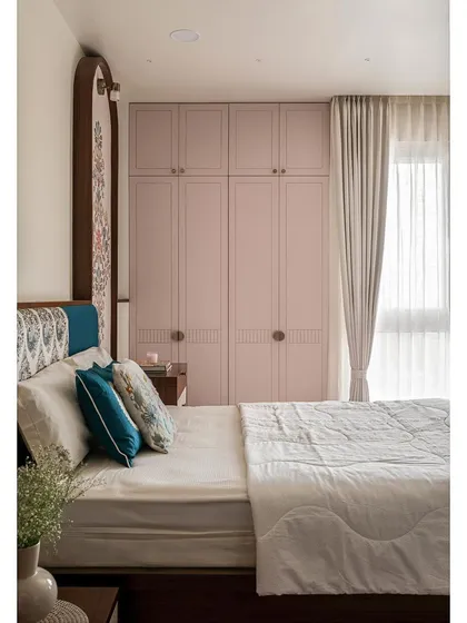 In this master bedroom, I blended traditional elegance with modern convenience. The wardrobe is finished in a chic pink hue, while a custom-made mural in an arched frame serves as a beautiful focal point.