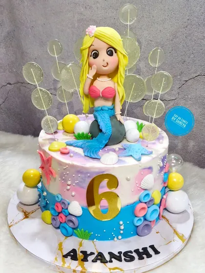 Dive into a magical underwater celebration with this mermaid-themed cake. It features a handcrafted mermaid figurine, colorful coral, seashells, and shimmering details to create an enchanting scene from under the sea.