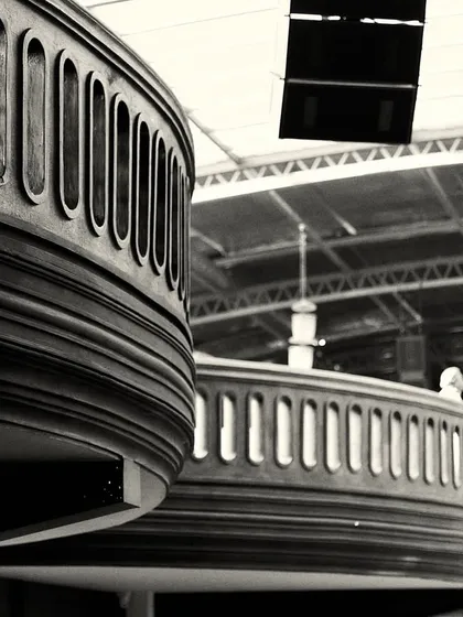 The repeating curves of the balconies create a sense of rhythm and movement throughout the large venue.