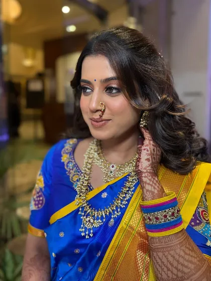 Another angle of this stunning engagement look, showcasing the soft curls in her hair and the flawless skin finish.