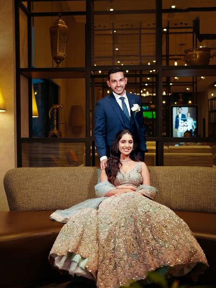 The couple posing in the lounge area. The bride's makeup is elegant and sophisticated, perfect for her reception.