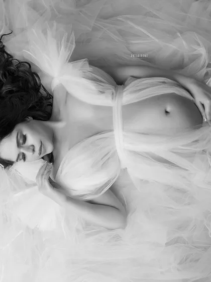 An ethereal overhead shot in black and white. The tulle fabric creates a cloud-like texture, turning this portrait into a piece of fine art.