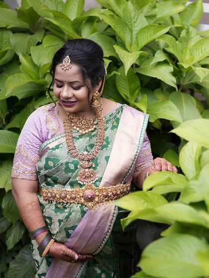 A close-up portrait amidst lush greenery, where the colors of the saree feel right at home. This is a look of pure, natural grace.