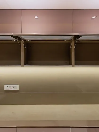 Bi-fold lift-up cabinets in the Malad project, demonstrating how we provide easy access to upper storage.