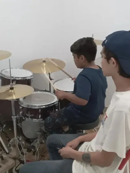 A drum student getting guidance from his instructor.