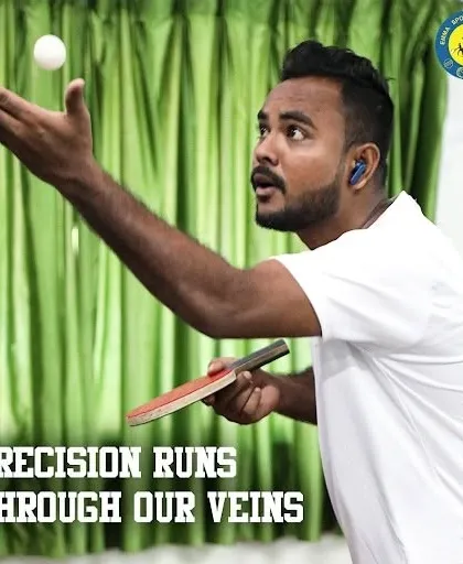 A player executes a high-toss serve with intense concentration. This level of precision is developed through dedicated practice in our air-conditioned TT zone.