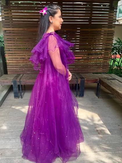A side view showing the flow of the gown and the simple floral hair accessory that adds a touch of softness to the look.