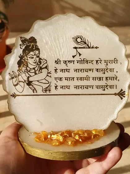 To bring positive energy to your home or workspace, I create simple and elegant mantra frames like this Shree Krishna piece. It features a beautiful prayer and an illustration of Lord Krishna, set in a pearlescent resin base with golden crystal accents.