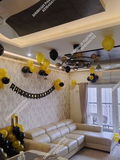 A simple and stylish birthday decoration for a living room with black and yellow balloons.