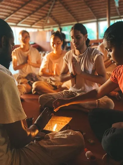 We gather for a sacred fire ceremony, or puja. A student participates in the ritual, an ancient practice of making offerings to the fire as a symbol of transformation and connection to the divine.