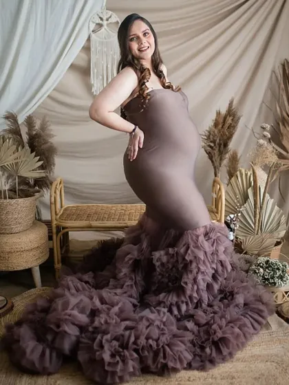 This mermaid-style maternity gown with a ruffled train looks incredible in my studio's boho-themed setup. The earthy tones of the dress and the decor create a warm and stylish vibe.