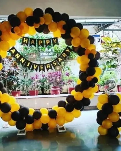 A bold black and yellow circular balloon arch for an anniversary. This striking color combination is perfect for making a statement in any space.