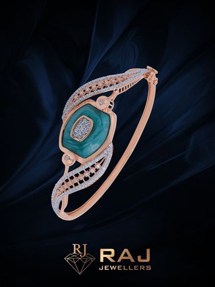 This contemporary bracelet features a central squared green stone, set on a sleek open-ended band with detailed CZ work. It is a modern and chic accessory.