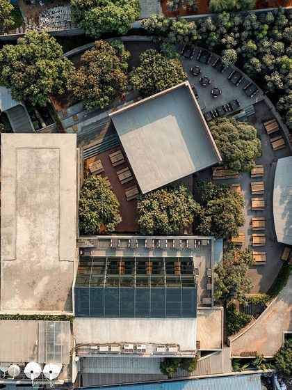An aerial view of the Zero40 Brewery, showing the relationship between the different outdoor zones, including sunken seating, a large deck, and areas shaded by mango trees. The design creates a multi-layered experience.