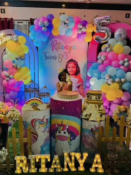 I love making parties personal. This unicorn-themed celebration for a 5th birthday features a custom backdrop with the child's photo, colorful balloon garlands, and their name in large, light-up marquee letters, creating a magical and unique focal point.