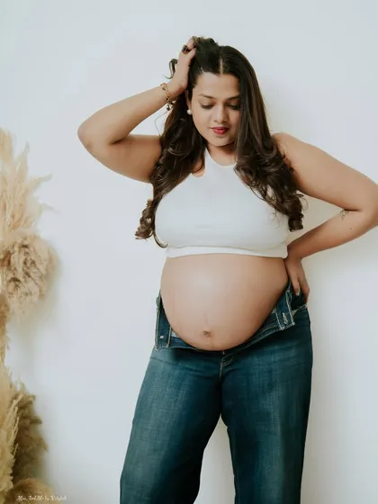 A confident and casual portrait of a mother-to-be in her favorite jeans. This shows that you can feel powerful and like yourself during your maternity shoot.