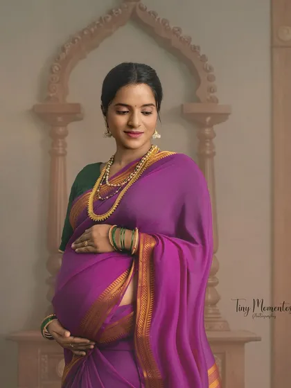 Framed by a traditional arch, this portrait captures a quiet moment of connection between mother and unborn child.