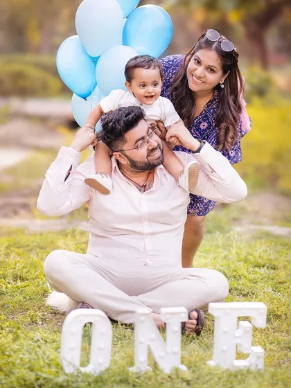 Family photoshoots aren't just for the studio. This outdoor session captures the playful, candid joy of a family celebrating their son's first birthday. The natural golden light and relaxed park setting allow for genuine interactions and happy memories.