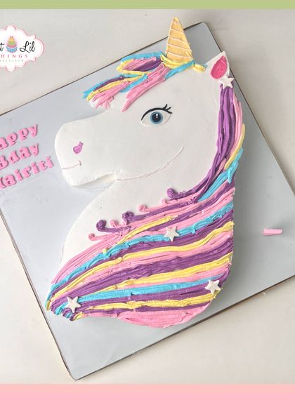 A magical unicorn cake with a colorful, flowing mane. This shaped cake is perfect for a whimsical birthday, decorated with pastel buttercream and little stars for an extra touch of sparkle.