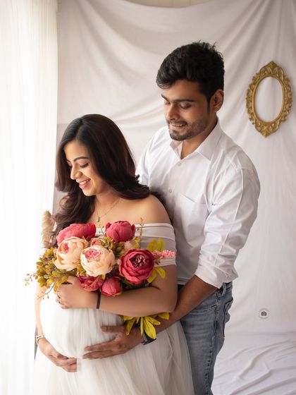 A candid moment of affection during a pregnancy photoshoot. His gentle embrace and her happy smile perfectly capture the love of this special time.
