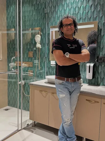 Here I am in a recently completed bathroom, showcasing the handmade green tiles that transform the wall into a stunning focal point.