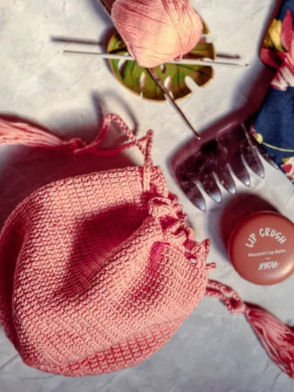 Styled with a few daily items, you can see how our crochet potli pouch is the perfect size for keeping your makeup and accessories organized inside a larger bag.