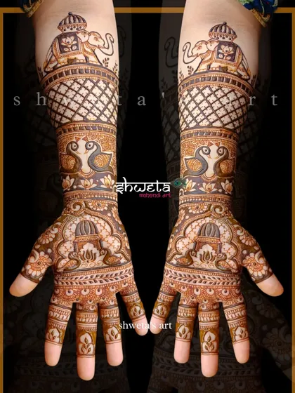 This design is a celebration of royalty. It features majestic elephants at the top, peacocks in the middle, and lotus motifs on the palm, all tied together with intricate jaal work.