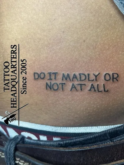 The motivational quote "DO IT MADLY OR NOT AT ALL" in a simple, impactful font, placed on the lower back.