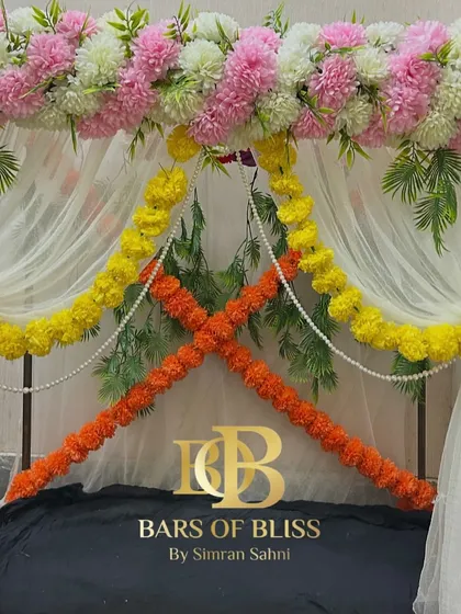 This image showcases a versatile floral frame that can be used for various festive occasions. The top is adorned with pink and white flowers, while marigold garlands can be added for a traditional touch.